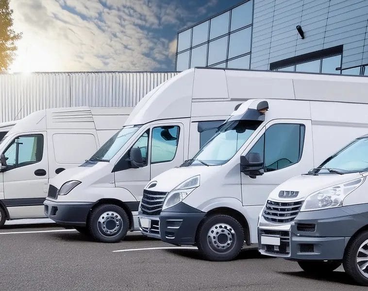 Close-up of white commercial van fleet parked at a modern depot